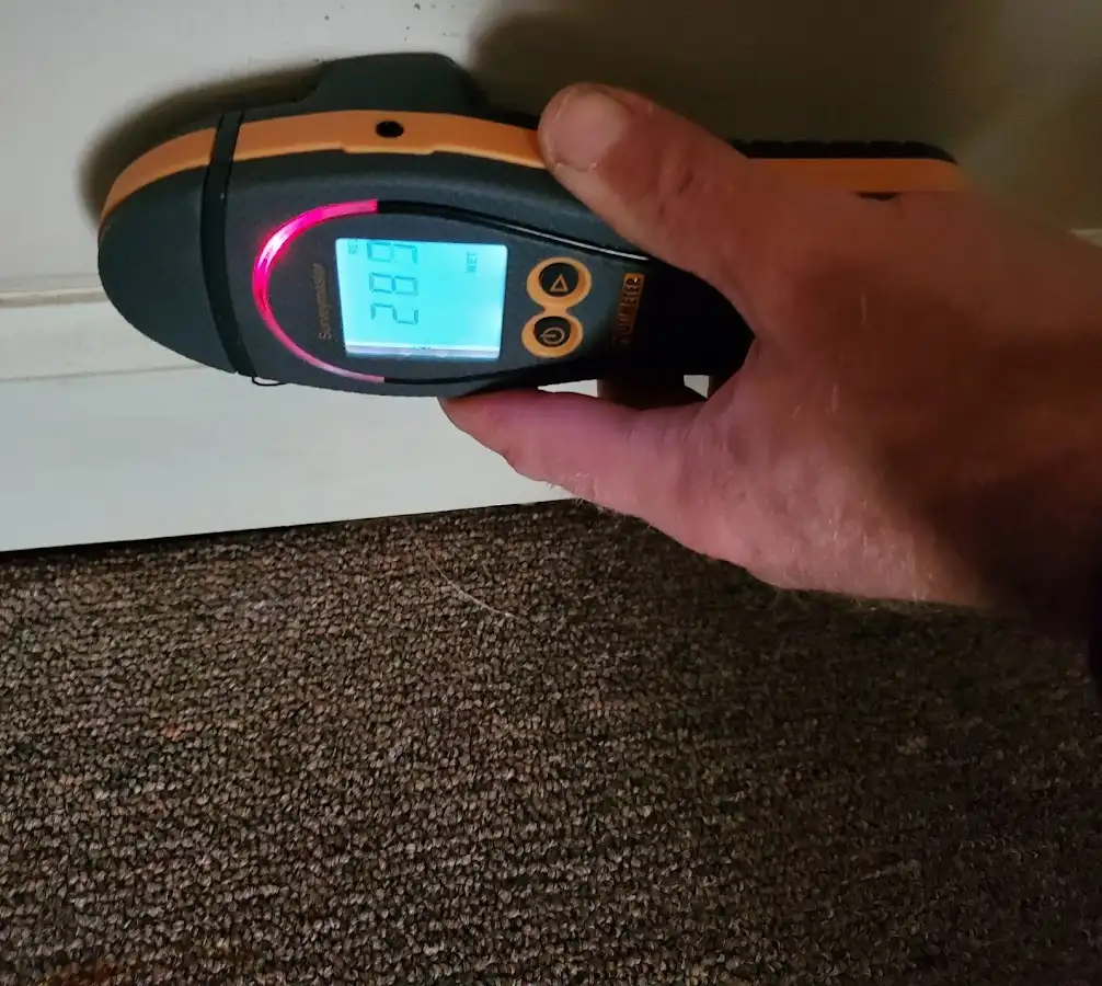 Moisture detection at baseboard during Storm Damage Restoration in Marvin